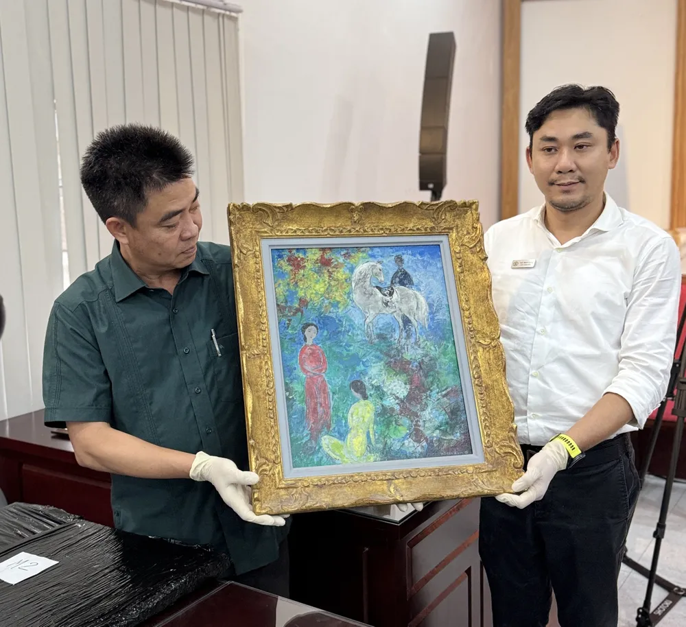 Ông Trần Minh Công, Phó Giám đốc phụ trách điều hành và quản lý Bảo tàng Mỹ thuật TPHCM (phải) cùng PGS-TS Lâm Nhân, Hiệu trưởng Trường Đại học Văn hóa TPHCM (trái), đại diện gia đình ông bà Lê Tất Luyện - Thụy Khuê mở niêm một tác phẩm IMG_9782.jpg