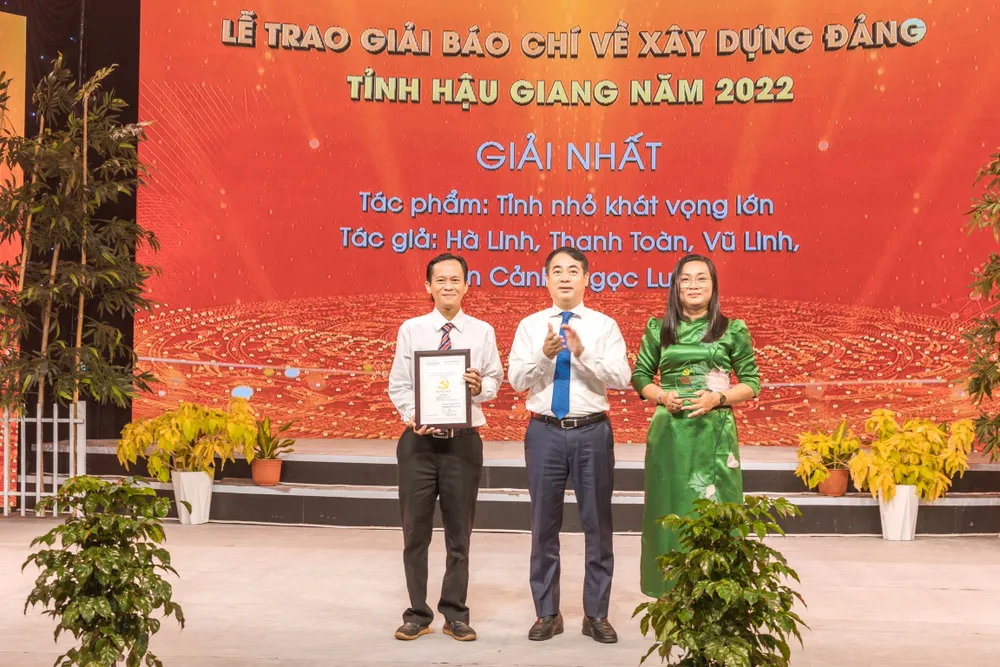 Ông Nghiêm Xuân Thành (đứng giữa) trao giải cho nhóm tác giả đoạt Giải nhất. Ảnh: TRUNG QUÂN