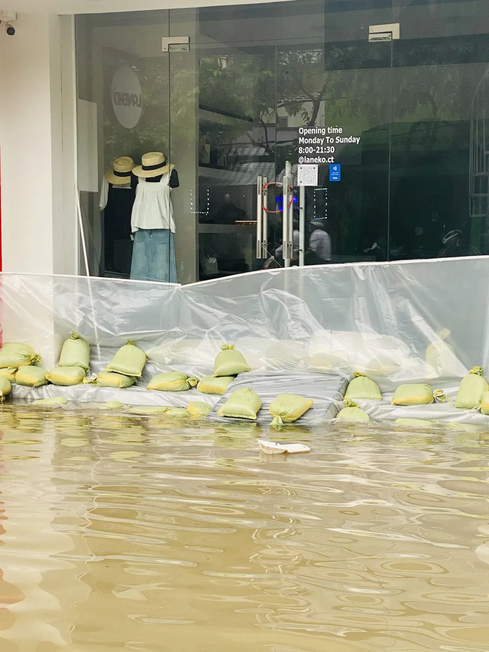 Người dân ở đường Lý Tự Trọng dùng bao cát chắn nước tràn vào nhà, sáng 2-10