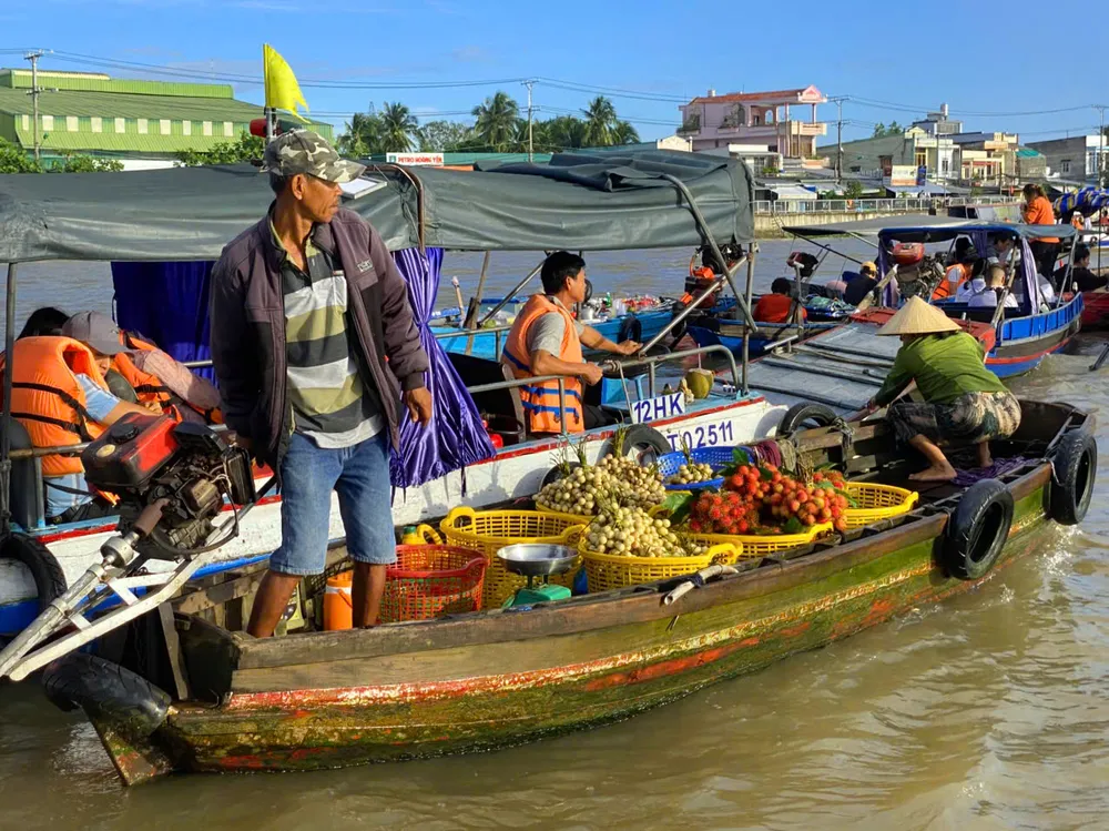 9- Mỗi khi tàu du lịch dừng lại, thì những người bán trái cây điều khiển ghe một cách điệu nghệ sát mạng sườn tàu du lịch để chào bán.jpg