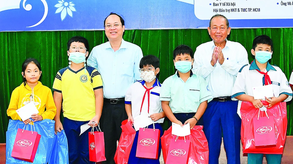 Nguyên Phó Thủ tướng Thường trực Trương Hòa Bình và Phó Bí thư Thành ủy TPHCM Nguyễn Hồ Hải tặng quà học sinh. Ảnh: VIỆT DŨNG