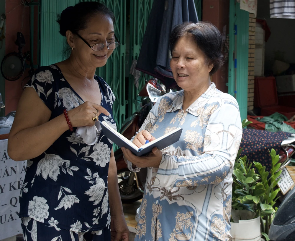 Bí thư chi bộ đồng thời là Trưởng khu phố 4, phường 1, quận 3 Nguyễn Thị Chiếm (bên phải) trao đổi với người dân trong khu phố