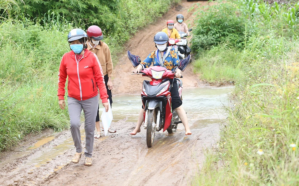 Giáo viên Trường Tiểu học Mạc Thị Bưởi băng rừng để lên lớp. Ảnh: MAI CƯỜNG 