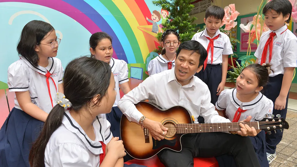 Thầy Lê Tấn Lộc cùng học sinh Trường Tiểu học Minh Đạo, quận 5 chuẩn bị văn nghệ mừng Ngày Nhà giáo Việt Nam. Ảnh: CAO THĂNG