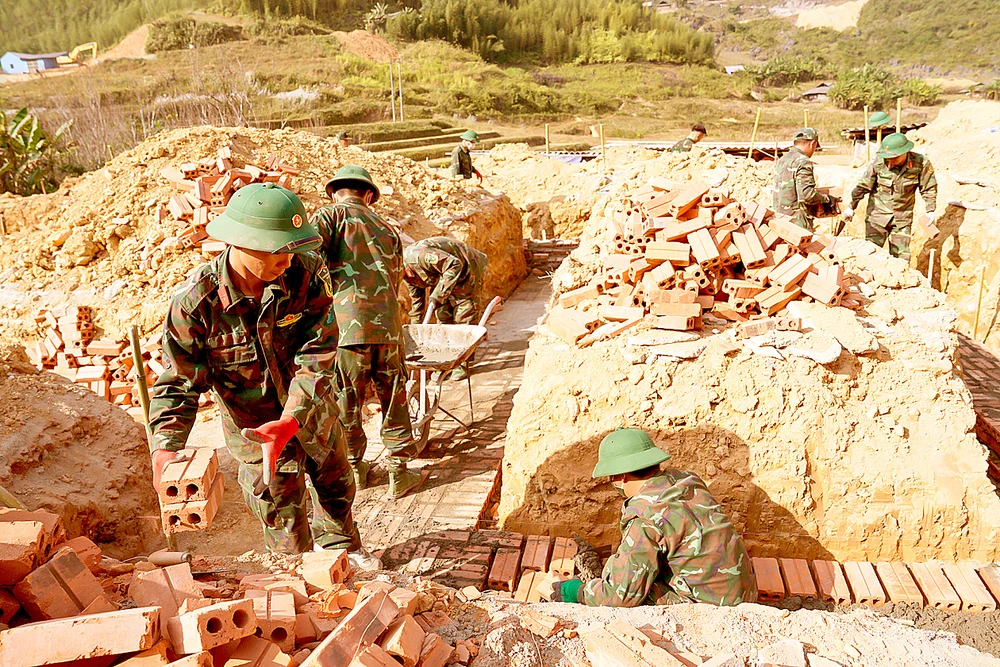 Cán bộ, chiến sĩ Bộ Chỉ huy Quân sự tỉnh Cao Bằng xây nhà tái định cư cho người dân xóm Lũng Cắm. Ảnh: ĐỖ TRUNG