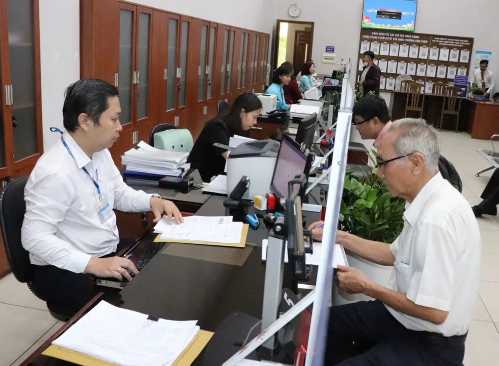 Cán bộ, công chức Bộ phận một của UBND quận 4 giải quyết hồ sơ cho ông Mai Vũ Khánh, sáng 30-6. Ảnh: THÁI PHƯƠNG 2.jpg