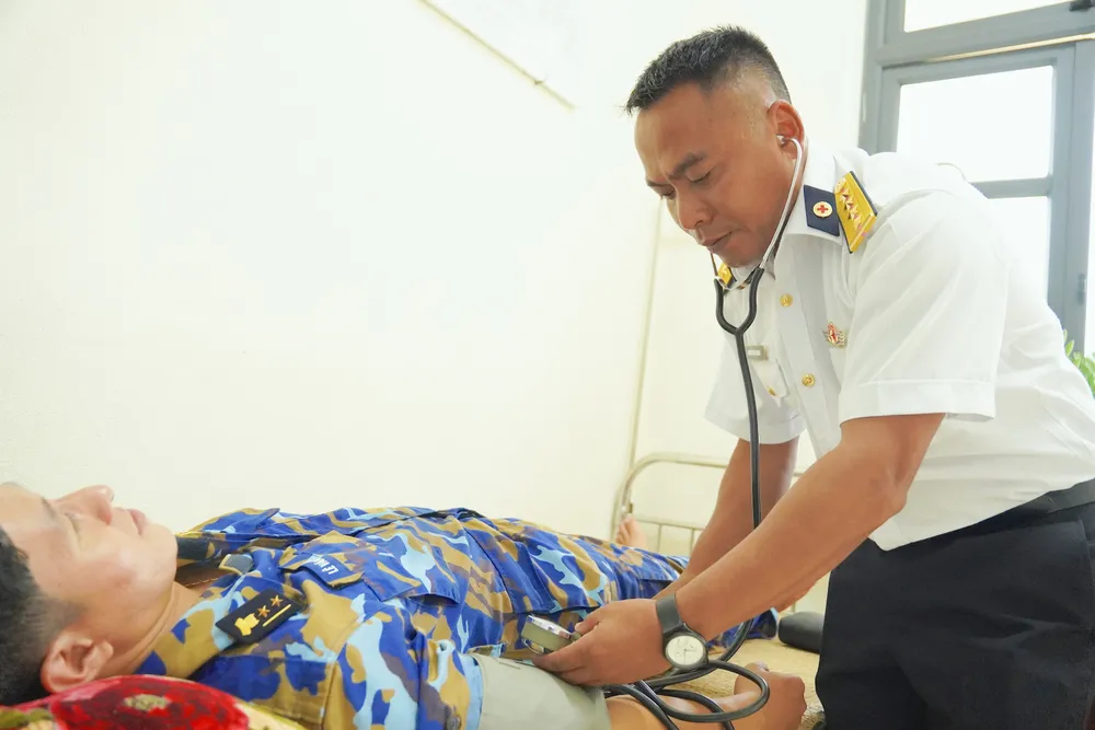 Đại úy quân y Nguyễn Văn Quang khám bệnh cho cán bộ chiến sĩ Trạm ra đa 595 - Trung đoàn 551, Vùng 5 Hải quân U5c.jpg