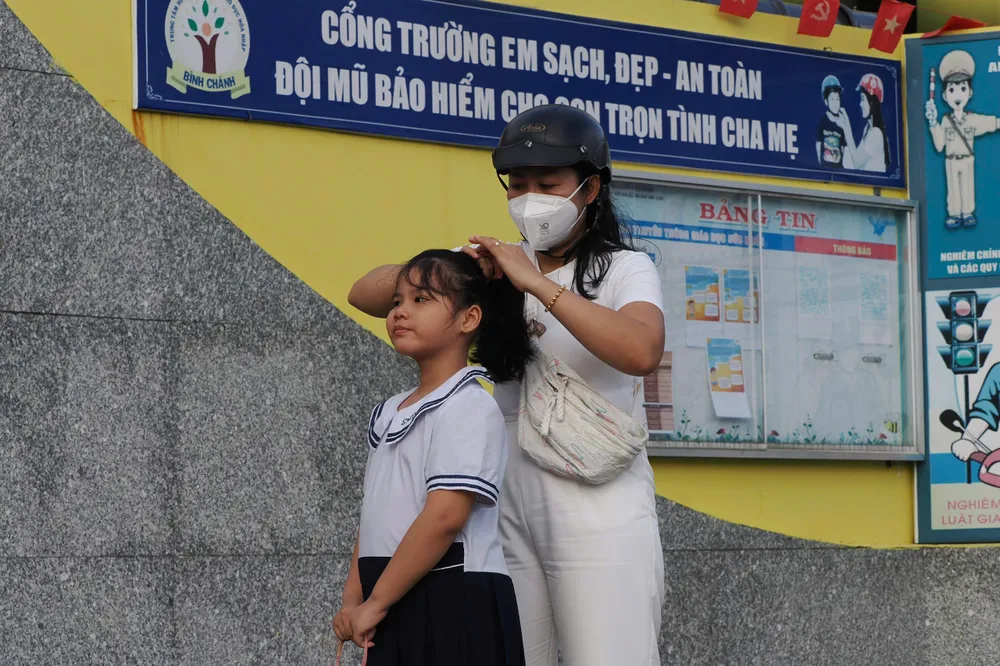 Mẹ chuẩn bị tươm tất cho con trước giờ dự lễ khai giảng đặc biệt. Ảnh: HOÀNG HÙNG Mẹ chuẩn bị tươm tất cho con trước giờ dự lễ khai giảng đặc biệt. Ảnh: HOÀNG HÙNG