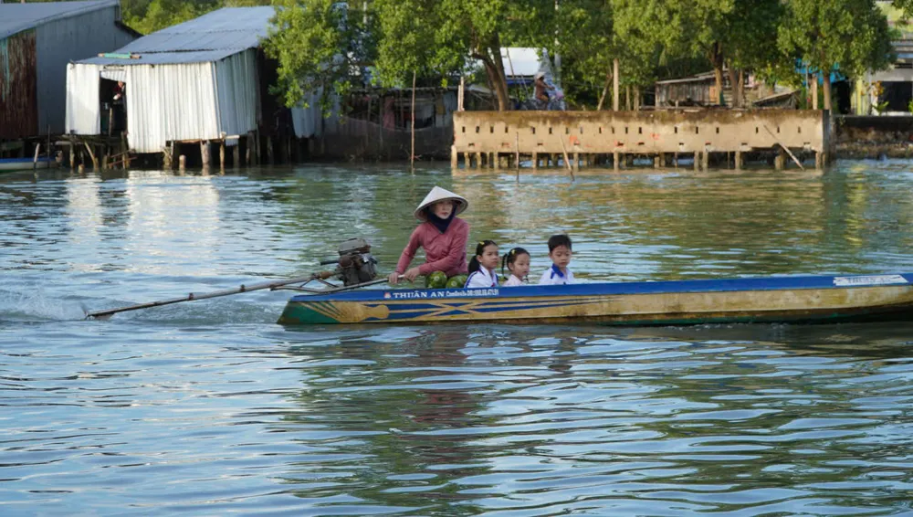 សិស្សសាលាបឋមសិក្សា Dat Mui 1 (ឃុំ Dat Mui ខេត្ត Ca Mau) ត្រូវបានឪពុកម្តាយនាំទៅសាលារៀនក្នុងសំប៉ាន។ រូបថត៖ តាន់ ថៃ z6978318417178_503a66eaa3f55900c9ca80d3305c7f92.jpg