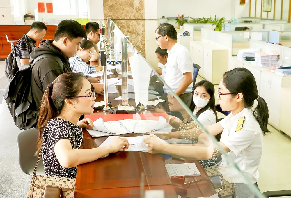 Tiếp nhận và giải quyết hồ sơ thuế tại trụ sở Thuế TPHCM. Ảnh: HOÀNG HÙNG