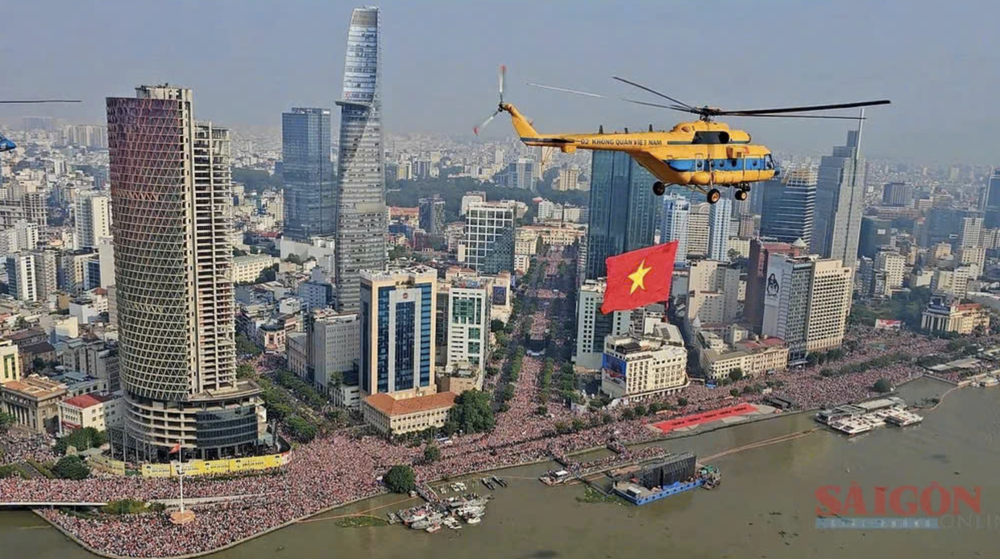 庆祝南方解放和国家统一50周年阅兵式上一架挂着国旗的直升机。