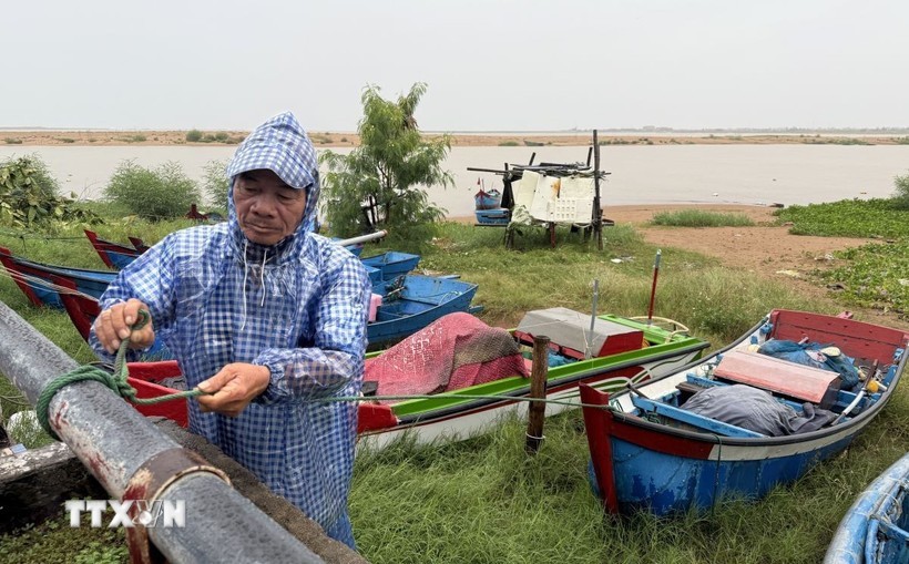 越南德乐省居民在13号台风登陆前固定船只。