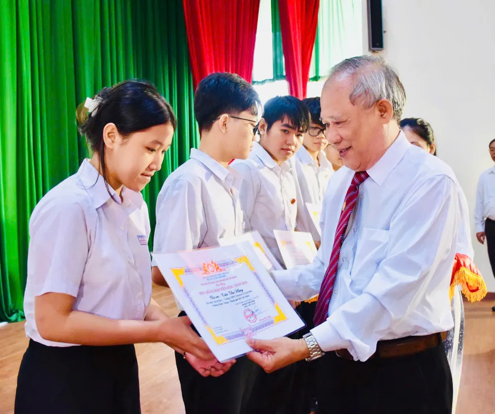 Ông Lương Đức Đích, Phó Chủ tịch Thường trực Hội Khuyến học TPHCM trao học bổng cho các em học sinh, sinh viên.