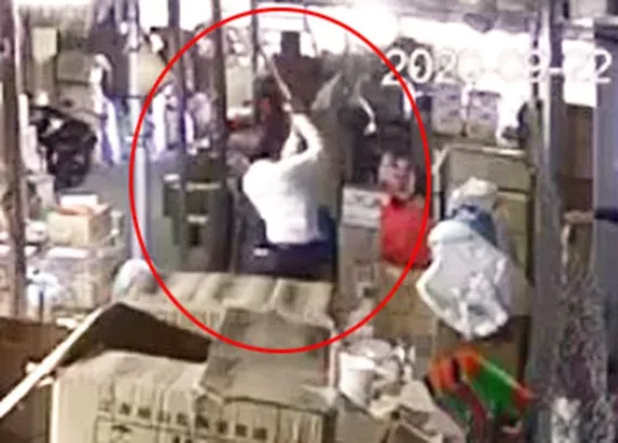 Đối tượng Hùng cầm cây gỗ dài hơn 1m đánh tới tấp vào vùng đầu, người của bà Q. Ảnh chụp từ clip