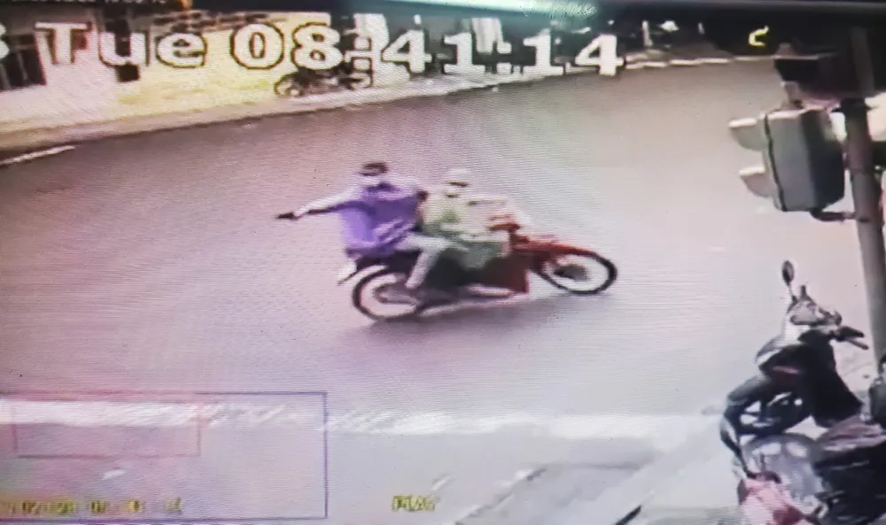 Thanh niên ngồi sau xe máy tay cầm vật màu đen phát ra tiếng nổ lớn nghi súng ngắn. Ảnh cắt từ clip người dân chia sẻ