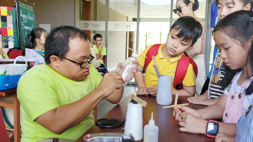 Thành viên vườn tái chế rác thải giúp bạn trẻ xây dựng mô hình đồ chơi tái chế. Ảnh: NGỌC OAI Thành viên vườn tái chế rác thải giúp bạn trẻ xây dựng mô hình đồ chơi tái chế. Ảnh: NGỌC OAI