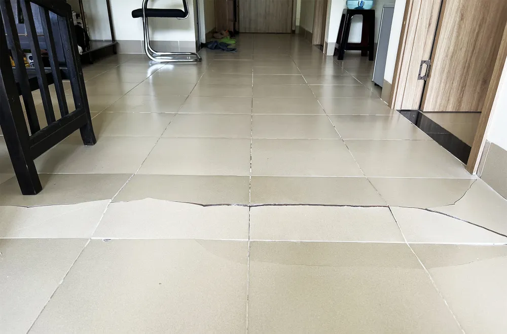 Nền gạch bên trong căn hộ nứt vỡ toác kéo dài nhiều mét Nền gạch bên trong căn hộ nứt vỡ toác kéo dài nhiều mét