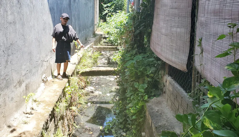Bà Võ Thị Bé Bảy bên mương thoát gây mùi hôi thối nặng