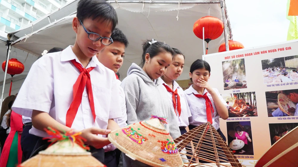 Các em học sinh tìm hiểu các hiện vật hành nghề của di sản nón ngựa Phú Gia. Ảnh: HOÀNG NGỌC z6592691422135_fa508cd29d693a6c4e13da11ef5a61dc.jpg