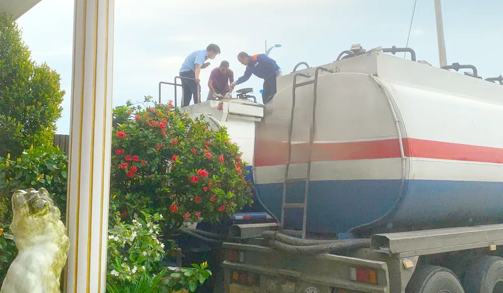 Lực lượng chức năng đang kiểm tra, giám định chất lỏng 2 xe tải bị tạm giữ. Ảnh: Chi cục QLTT Bình Định 3 (1).jpg