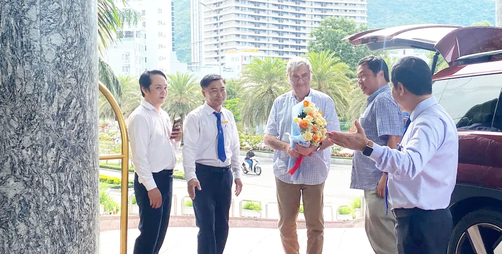 Giáo sư Serge Haroche (cầm hoa) đến phường Quy Nhơn Nam để chuẩn bị tham gia hội nghị. Ảnh: ICISE z7087707978761_6589297cca01cca9a1caf7764a33edce.jpg