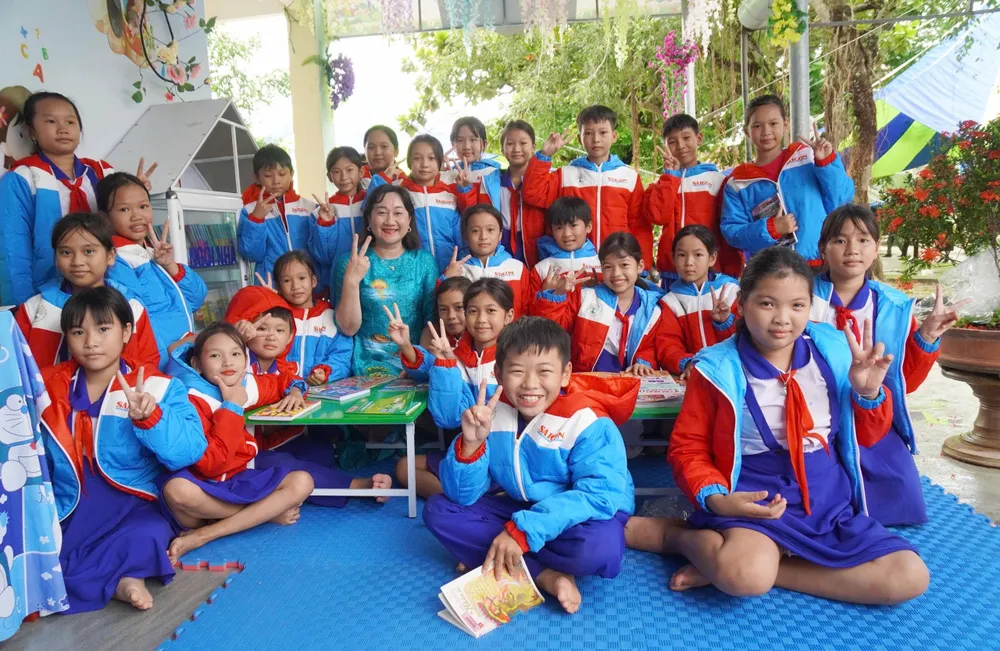 Bà Bùi Thị Hồng Sương cùng các em học sinh trải nghiệm tại "Thư viện xanh" z7178142959160_b62aa585039eca7a2c4f8a02f6cebf15.jpg