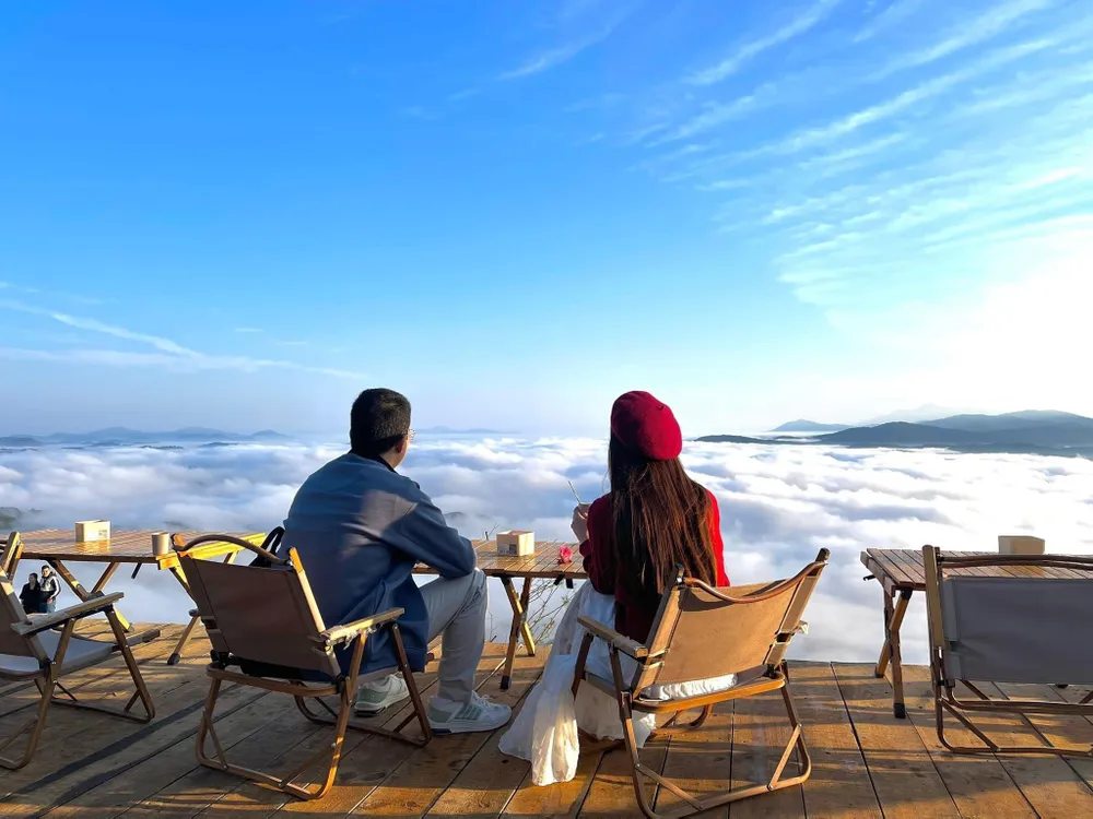 Một cặp đôi đang uống trà, trò chuyện giữa không gian nên thơ của những đám mây bồng bềnh. Dù vượt quãng đường dài để đến với Đà Lạt, nhưng nhiều bạn trẻ sẵn sàng dậy rất sớm từ lúc 3-4 giờ sáng để tận hưởng cảm giác có một không hai ở đây.