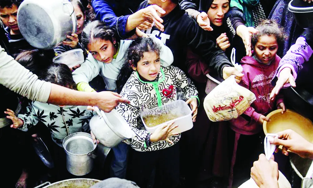 Người dân Palestine nhận viện trợ lương thực tại trại Al-Shati, phía Tây thành phố Gaza. Ảnh: Xinhua #8c.jpg