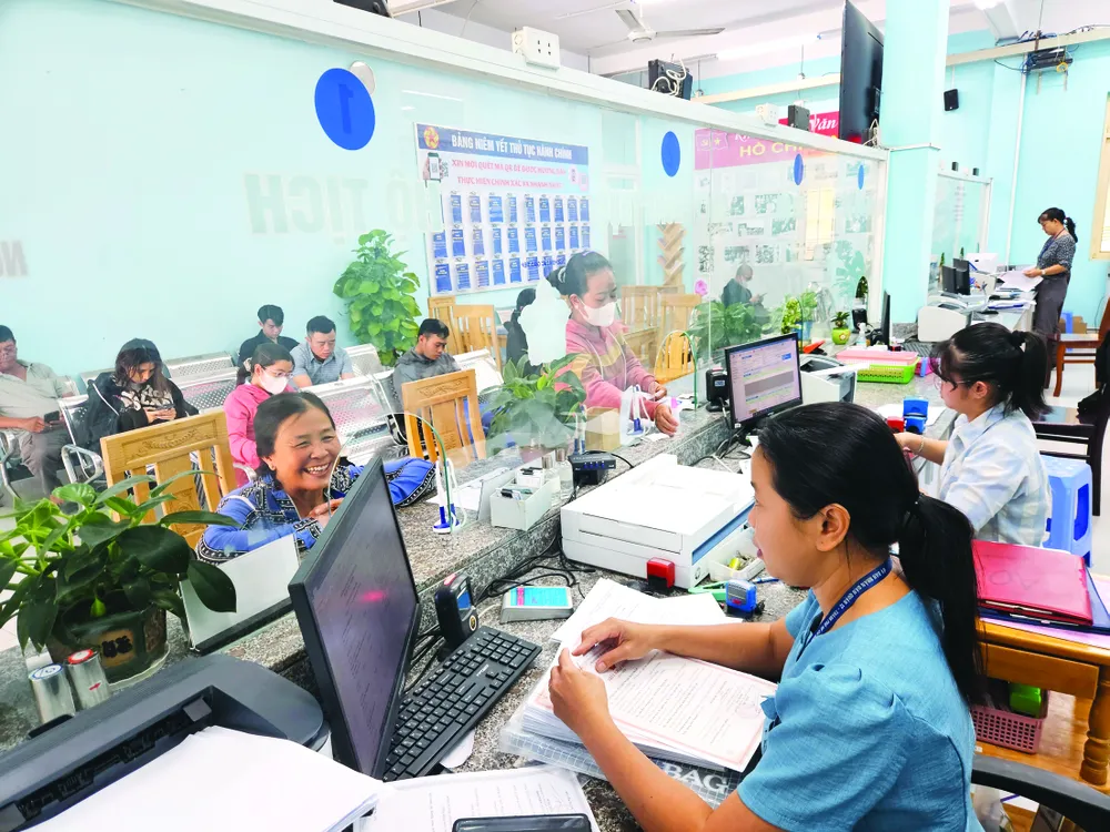 Công chức phường An Phú Đông (quận 12, TPHCM) giải quyết hồ sơ thủ tục hành chính cho người dân. Ảnh: NGÔ BÌNH %1a.jpg
