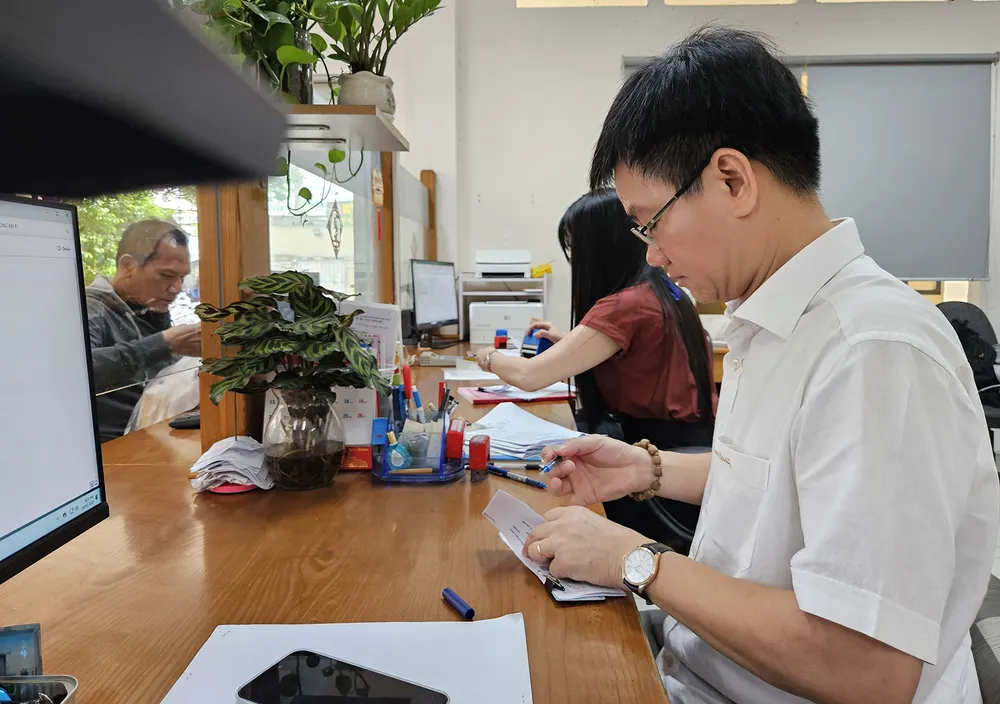Chủ tịch UBND phường 1 (quận Gò Vấp, TPHCM) trực tiếp ký hồ sơ cho người dân tại bộ phận một cửa. Ảnh: NGÔ BÌNH %3b.jpg