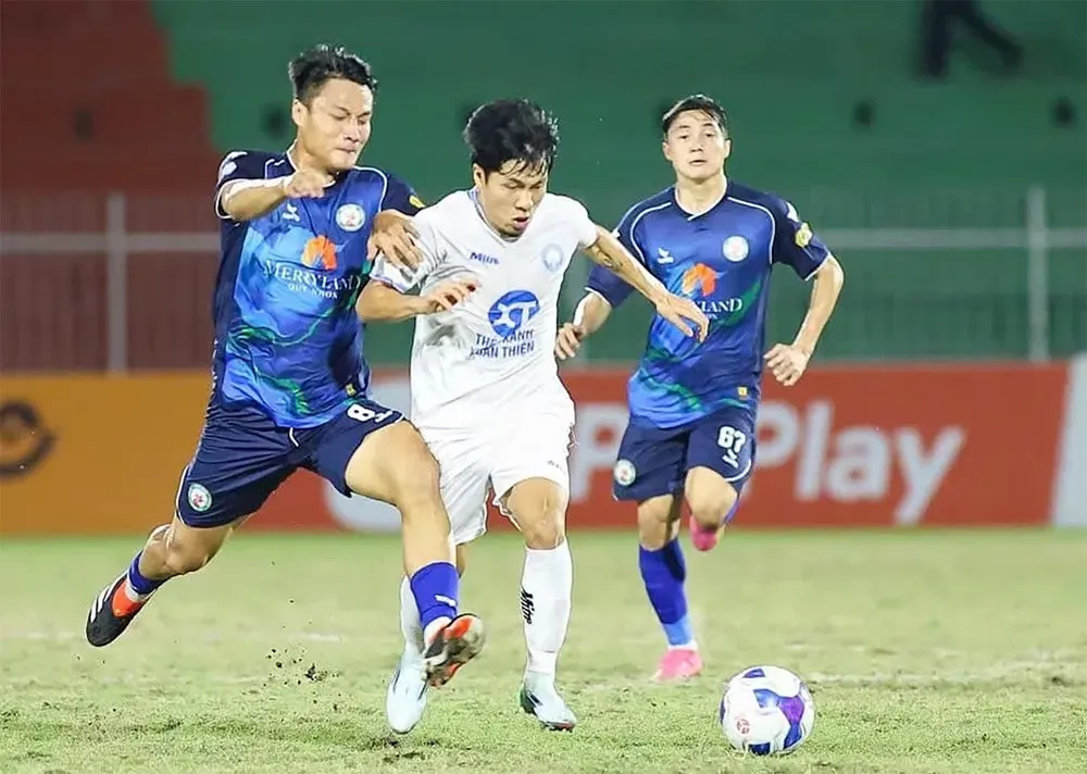 Cầu thủ Bình Định (trái) nỗ lực truy cản cầu thủ Nam Định ở V-League 2024-2025. Ảnh: P.MINH X6b.jpg