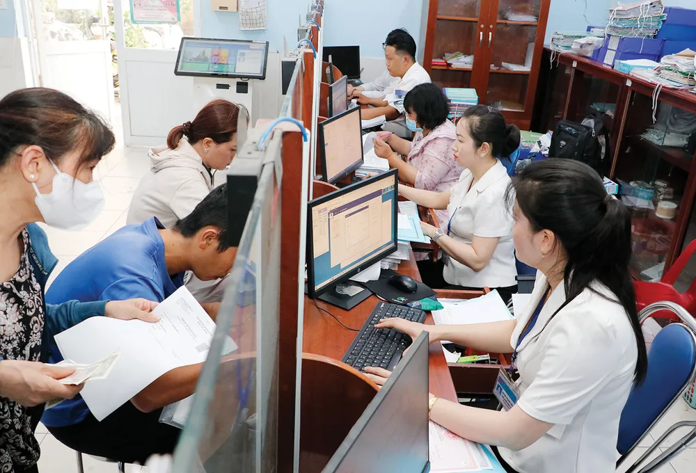 Công chức UBND xã Vĩnh Lộc A, huyện Bình Chánh, TPHCM giải quyết hồ sơ thủ tục hành chính cho người dân. Ảnh: NGÔ BÌNH hanh-chinh.jpg