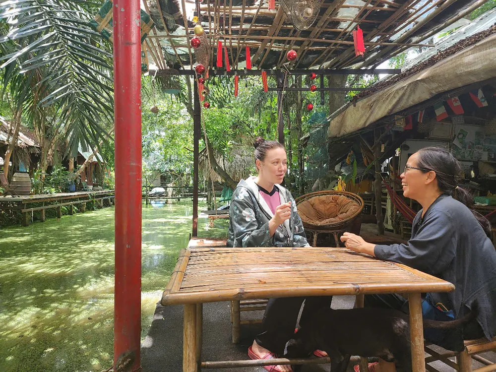 Chị Juley Jasmin (khách du lịch đến từ Nam Phi) trò chuyện với chủ nông trại Tam Nông (phường An Phú Đông, TPHCM). Ảnh: ĐỨC TRUNG D5c.jpg