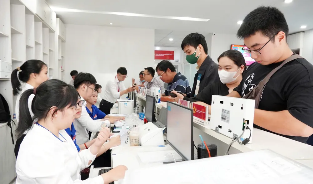 Công chức phường Bến Thành, TPHCM tiếp nhận và giải quyết thủ tục hành chính cho người dân. Ảnh: THU HƯỜNG J1b.jpg