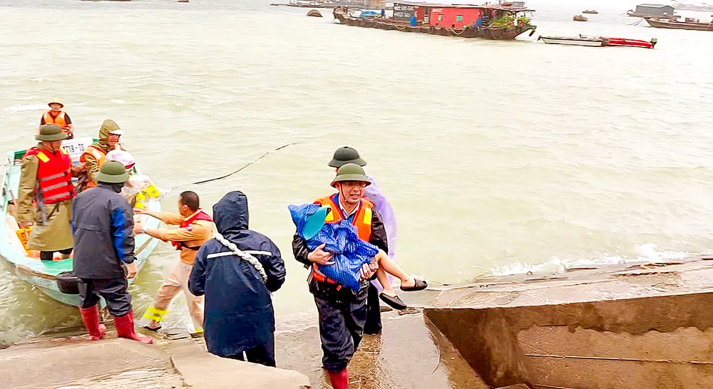 Bộ đội biên phòng ở Đặc khu Cô Tô (Quảng Ninh) hỗ trợ người dân trên các lồng bè đi chuyển lên bờ an toàn. Ảnh: THU BÁU V7a.jpg