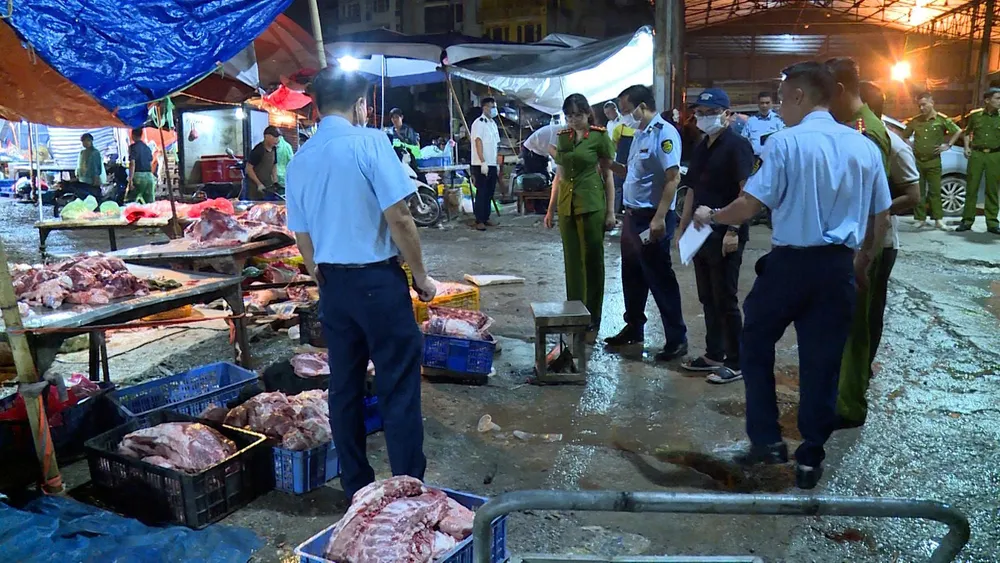 Lực lượng chức năng kiểm tra các sạp thịt heo ở chợ Phùng Khoang (Hà Nội). Ảnh: VĂN PHÚC E5c.jpg