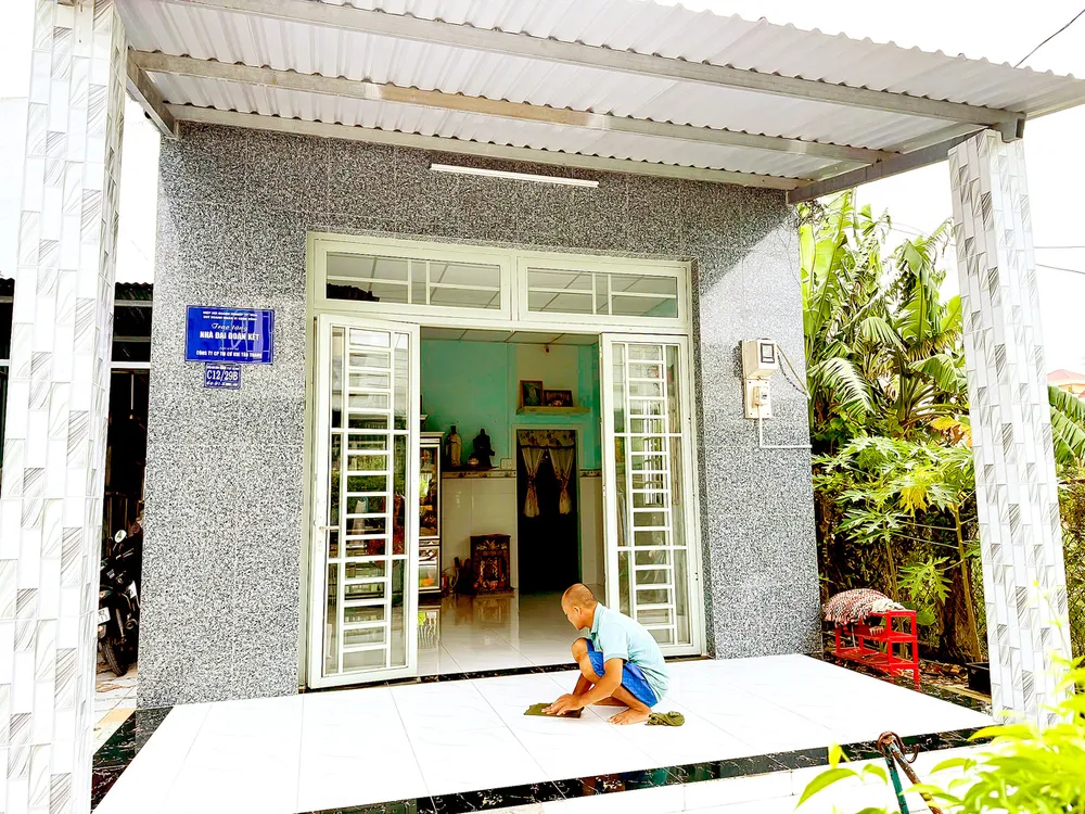Ông Phạm Hồng Nhân (xã Hưng Long, TPHCM) lau từng ô gạch trong căn nhà mơ ước của 2 vợ chồng. Ảnh: CẨM NƯƠNG H1b.jpg