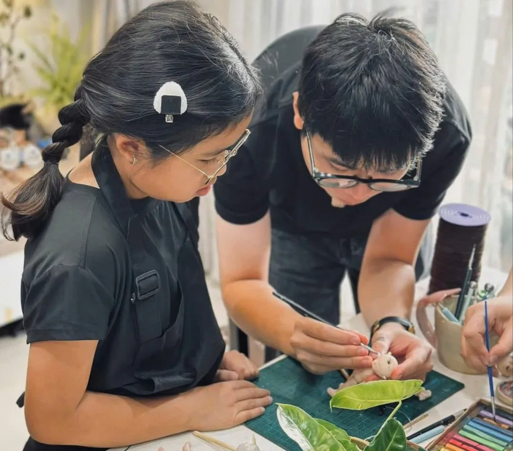 Thịnh Đa hướng dẫn một thiếu nhi cách nặn búp bê theo phong cách riêng F6A.jpg