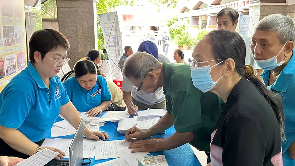 HCM City Social Insurance staff pay pensions and social insurance benefits to beneficiaries. Photo: DONG SON R4a.jpg