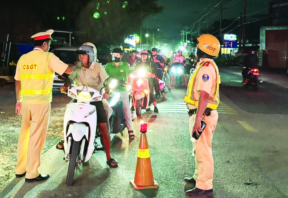 Cảnh sát giao thông đo nồng độ cồn người tham gia giao thông trên đường ĐT 747, đoạn qua phường Tân Uyên, TPHCM. Ảnh: VĂN CHÂU X1b.jpg