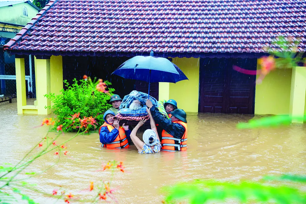 Lực lượng chức năng TP Huế đưa người lớn tuổi ra khỏi ngôi nhà ngập trong lũ, chiều 27-10 $1b.jpg