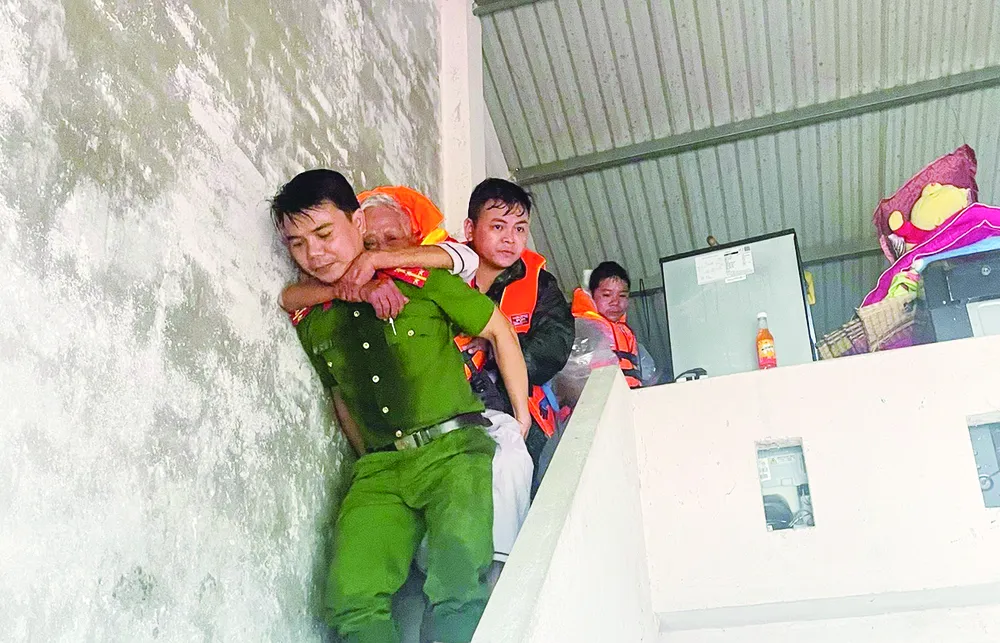 Công an TP Đà Nẵng hỗ trợ người dân xã Quế Phước đến nơi tránh lũ $1c.jpg