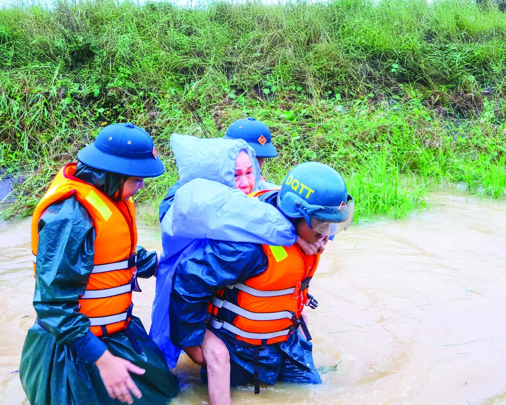 Lực lượng chức năng TP Đà Nẵng sơ tán người dân khỏi vùng ngập. Ảnh: PHẠM NGA chu de.jpg