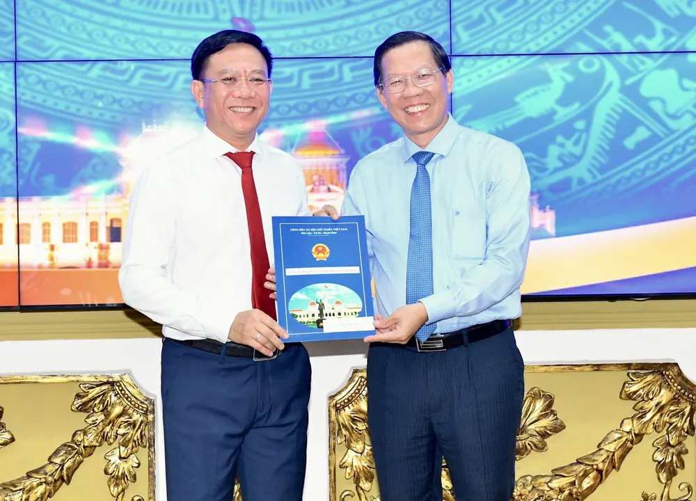 Chủ tịch UBND TPHCM Phan Văn Mãi trao quyết định cho ông Nguyễn Ngọc Hồi. Ảnh: VIỆT DŨNG.