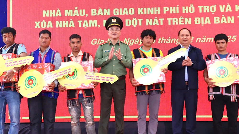 Trung tướng Phạm Thế Tùng (giữa) trao chìa khóa tượng trưng cho các hộ dân ở Gia Lai được Bộ công an hỗ trợ nhà ở vào tháng 2-2025 U4a.jpg