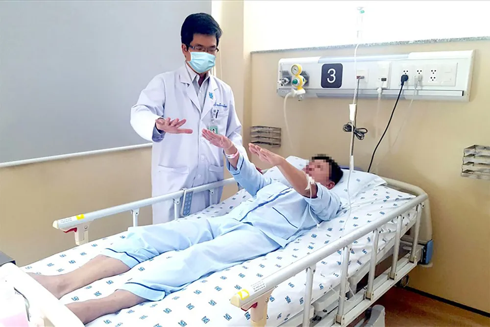 TS-BS Nguyễn Bá Thắng, Trưởng Đơn nguyên Đột quỵ Bệnh viện Đại học Y Dược TPHCM thăm khám cho người bệnh. Ảnh: THÀNH AN I4c.jpg
