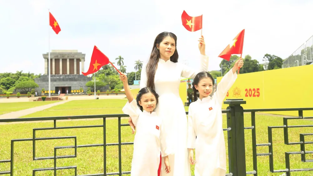 Chị Thúy Linh (quận Hoàn Kiếm, Hà Nội) cùng hai con gái chụp bộ ảnh lưu niệm tại Quảng trường Ba Đình từ 6 giờ sáng 11-8