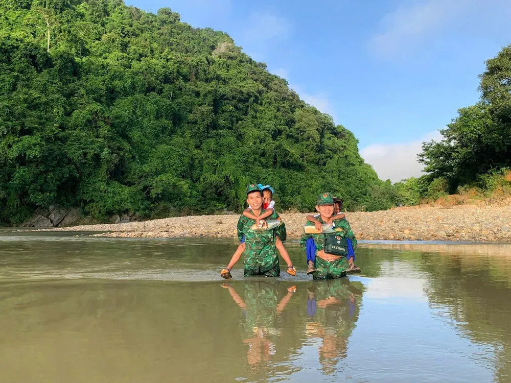 Cán Bộ Đồn Biên Phòng Cù Bai (Quảng Trị) đưa học sinh Thôn Cù Bai đi khai giảng. Ảnh: VĂN THẮNG 3716759965523469967.jpg
