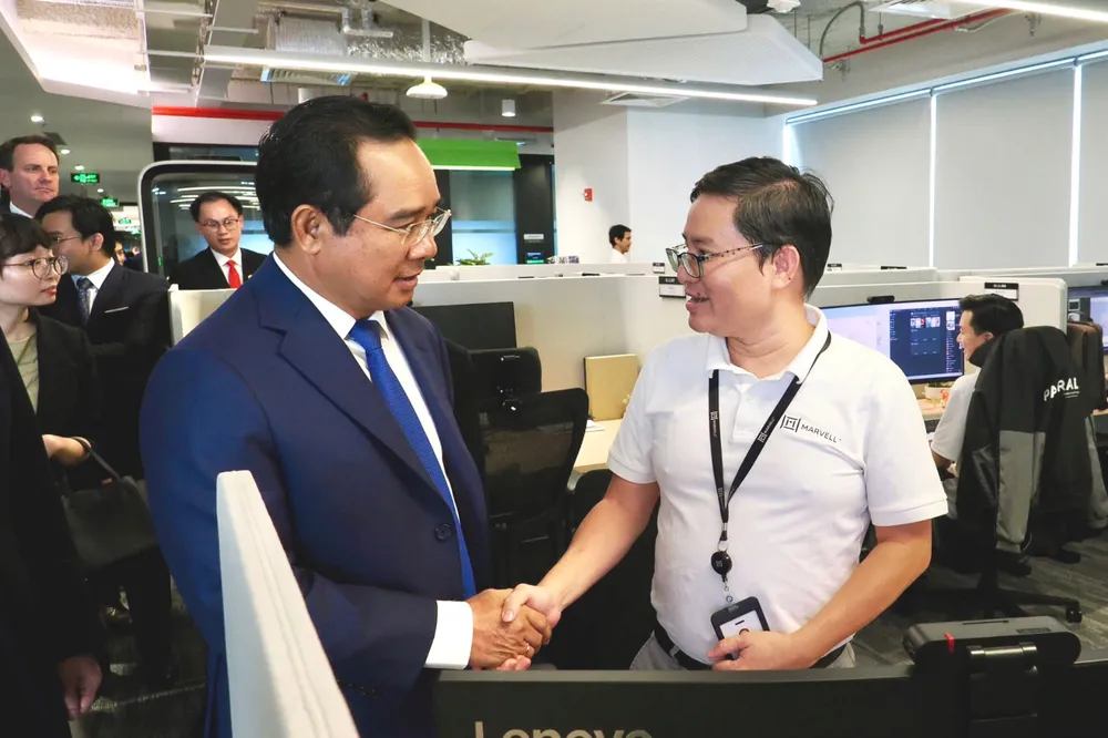 Chủ tịch UBND TPHCM Nguyễn Văn Được với nhân viên phòng Lab của Marvell Technology Việt Nam. Ảnh: HOÀNG HÙNG z7065240103910_296f60b38bb5f1e42e3b2722e0f2a238.jpg