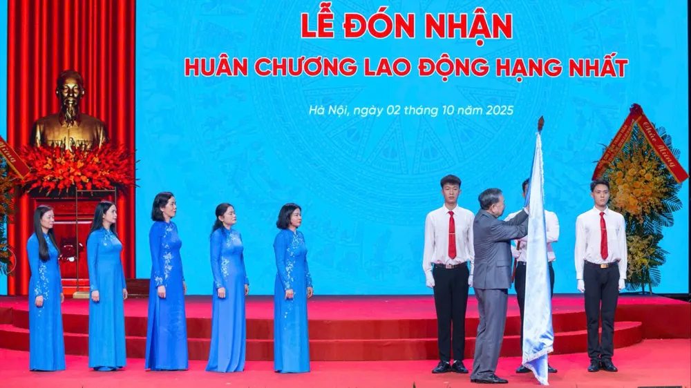Tổng Bí thư Tô Lâm gắn Huân chương Lao động hạng nhất lên lá cờ truyền thống của Hội LHPN Việt Nam. Ảnh: VIẾT CHUNG